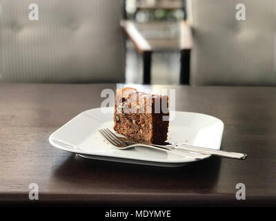 Pineapple and Carrot Cake Slice served with fork at cafe shop. Dessert Concept. Stock Photo