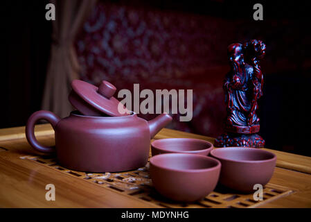 Clay tea set stands on a wooden board. Stock Photo