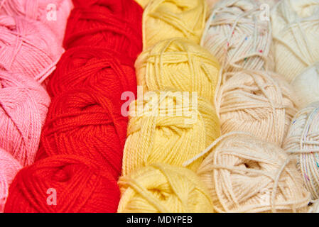 Rows of bright multi-colored tangles of yarn close-up. Stock Photo