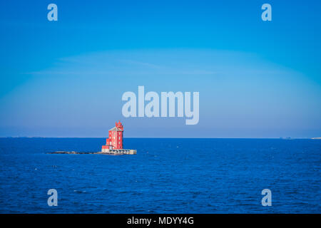 Outdoor view of the red lighthouse on the Norwegian sea over a rock Stock Photo