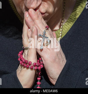 Woman Praying While Holding Rosary Beads Stock Photo