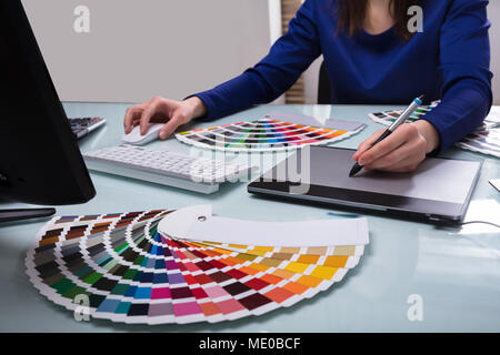 Designer's Hand Drawing On Graphic Tablet While Working On Computer Stock Photo