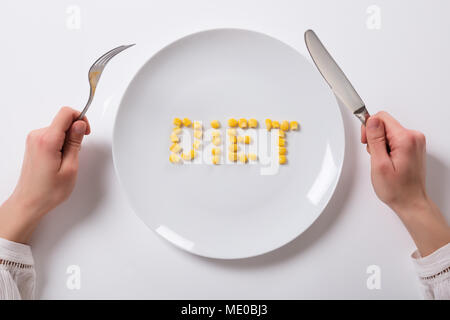 Woman's Hand With Corn Grains On Plate Showing Diet Text Stock Photo