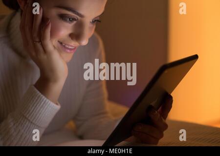 Young woman using digital tablet, smiling. Stock Photo