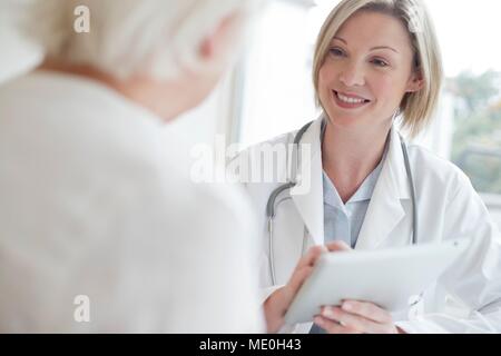 Female doctor using digital tablet with patient.