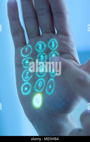 Mobile phone keypad projected on hand. Stock Photo
