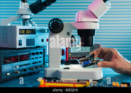 Examining circuit board with microscope. Stock Photo