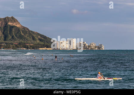 View of Diamond Head, Waikiki, and the two major Hawaiian watersports outrigger canoeing and surfing, from Magic Island, Ala Moana Beach Park Stock Photo