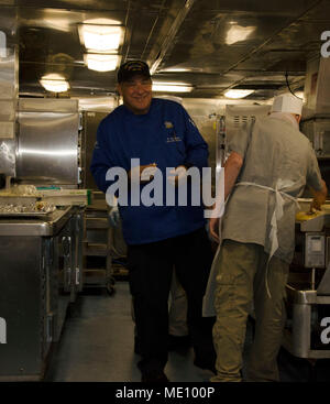 PORTLAND, Ore. (Dec. 13, 2017) - Fred Parmenter, an Executive Chef and Culinary Educator from Advanced Systems Information Group, smiles while helping prepare for lunch while aboard the submarine tender USS Frank Cable, Dec. 13, 2017. Frank Cable, currently in Portland, Ore. for her dry-dock phase maintenance availability, conducts maintenance and supports submarines and surface vessels deployed to the Indo-Asia-Pacific region. (U.S. Navy photo by Mass Communication Specialist Seaman Randall W. Ramaswamy) Stock Photo