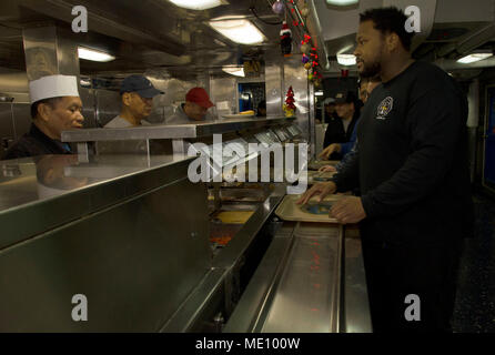 PORTLAND, Ore. (Dec. 13, 2017) - Sailors and Military Sealift Command civilian mariners line up to be served lunch aboard the submarine tender USS Frank Cable. Frank Cable, currently in Portland, Ore. for her dry-dock phase maintenance availability, conducts maintenance and supports submarines and surface vessels deployed to the Indo-Asia-Pacific region. (U.S. Navy photo by Mass Communication Specialist Seaman Randall W. Ramaswamy) Stock Photo