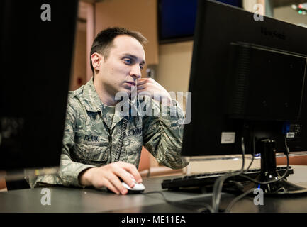 92nd Air Refueling Wing Command Post is a control center at Fairchild Air Force Base supporting installation command and control operations. On December 15, 2017, the archival image records a staff sergeant emergency controller working at a computer while performing duties such as flight following, notification, and operation of the Giant Voice system. Stock Photo