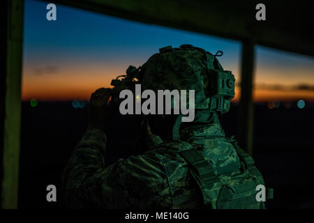 Airman Jasmine Castaneda, 9th Security Forces Squadron defender, adjust her night vision goggles during weapons training at Beale Air Force Base, Dec. 20, 2017. Night vision goggles are used in low light or no visibility in order to see targets. (U.S. Air Force photo by Senior Airman Colville McFee/Released) Stock Photo