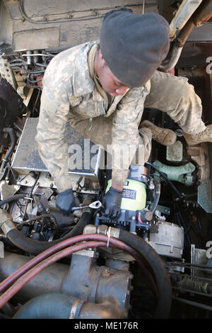 U.S. Army Pfc. Kiersten Letang a Multiple Launch Rocket System (MLRS) Repairer with B Battery, 1st Battalion, 38th Field Artillery Regiment, 2nd Infantry Division/ROK-US connects the ground cable to the alternator on a M993 Carrier Vehicle in South Korea, Dec. 8, 2017. Repairers are trained to quickly troubleshoot and fix the MLRS in any enviroment to ensure mission readiness at all times. (U.S. Army photo by Staff Sgt. Carl Greenwell) Stock Photo