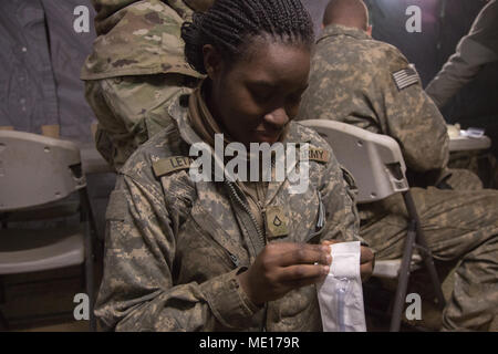 U.S. Army Pfc. Kiersten Letang, Bravo Battery, 1st Battalion, 38th Field Artillery Regiment, 210th Field Artillery Brigade, 2nd Infantry Division/ROK-US opens package in South Korea, Dec. 8, 2017. CLS training is important in saving peoples lives both in the field and around the unit. (U.S. Army photo by Pfc. Isaih Vega) Stock Photo