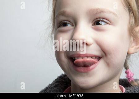 Happy little girl showing her tongue. Stock Photo