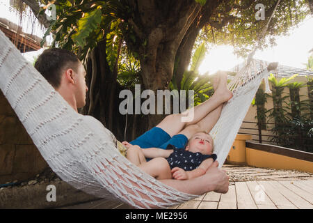 Baby and father are sleeping in a hammock Stock Photo