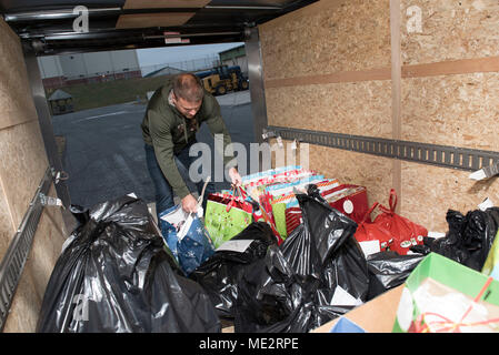 Master Sgt. Charles Moore , a loadmaster for the 167th Operations Group, loads gifts for local students in to his trailer to deliver them to local schools as part of the Ops Adopts porgram, Dec. 18. The Ops Adopts program was spearheaded by First Lt. Ryan Day, a pilot for the 167th Airlift Wing. (U.S. Air National Guard photo by Senior Master Sgt. Emily Beightol-Deyerle) Stock Photo