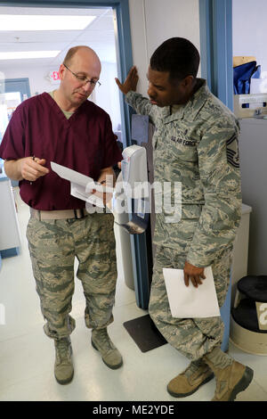 Lt. Col. Gregory Schmidt, 122nd Fighter Wing, Indiana Air National Guard, and Senior Master Sergeant Mark Patrick, 433rd Aerospace Medicine Squadron, Lackland AFB TX discuss the daily Situation Report (SITREP), April 17 2018 at the Kivalina Clinic, Kivalina Alaska. Schmidt and Patrick along with a joint and multinational force provided medical, dental, optometry and veterinary care for underserved villages in the Maniillaq Service Area April 16-24, in support of Arctic Care 2018. (U.S. Air Force photo by Maj. Joe Simms) Stock Photo