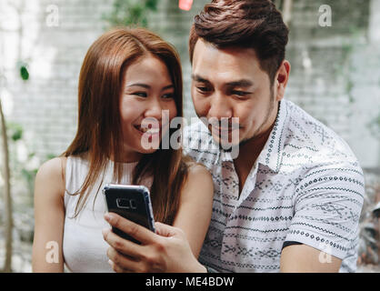Young couple using a phone together Stock Photo