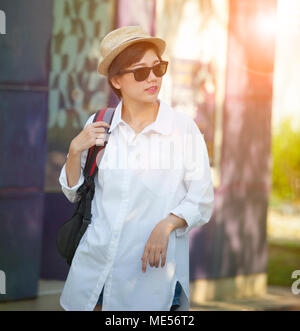 portrait of younger asian woman wearing straw hat and sun glasses relaxing traveling Stock Photo