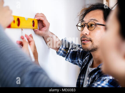 Asian couple measuring the wall Stock Photo