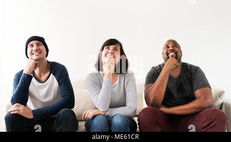 Group of diverse friends sitting on couch Stock Photo