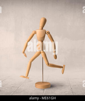 Wooden mannequin posed in front of a greyish background Stock Photo