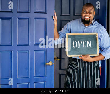 A cheerful small business owner with open sign Stock Photo
