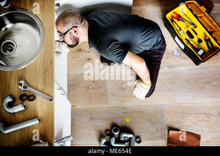 Man fixing kitchen sink Stock Photo