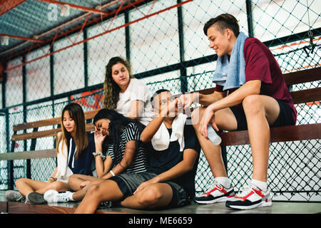 Group of young teenager friends sitting on a bench relaxing Stock Photo