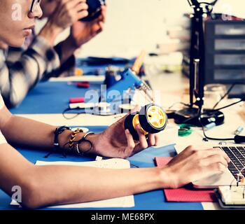Side view of man working on robot Stock Photo