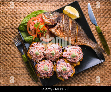 fried fish with fried plantain and salad, beach food in Venezuela Stock Photo