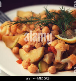 Vegetable stew with chickpeas, cauliflower and cabbages. Organic food. Vegan dish. European cuisine. Vegetarian lunch. Toned photo. Close up. Stock Photo