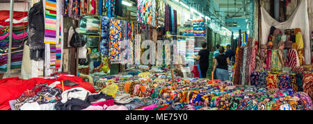 Colourful bolts of cloth on display in stalls in a fabric market in Ho Chi Minh City, Vietnam. Stock Photo