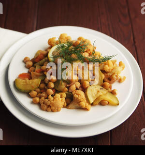 Vegetable stew with chickpeas, cauliflower and cabbages. Close up. Vegan dish. European cuisine. Vegetarian lunch. Toned photo. Stock Photo