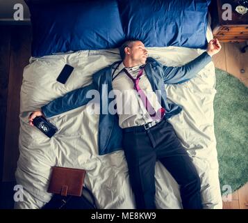 Drunk business man falling asleep as soon as he came back home Stock Photo