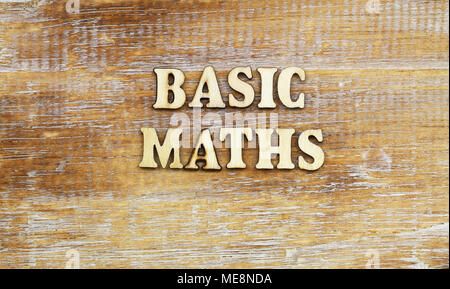 Basic maths written with wooden letters on rustic surface Stock Photo
