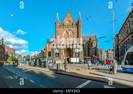 Tourists and locals cross a busy intersection in front of the Nieuwe kerk (New church) located on Dam square in Amsterdam, Netherlands city center Stock Photo