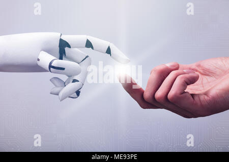 Robot Touching Human Finger Against Technology Background Stock Photo