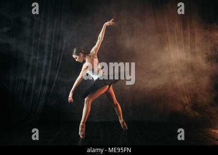 Attractive ballerina in action, dance training on the stage. Classical ballet dancer in motion Stock Photo