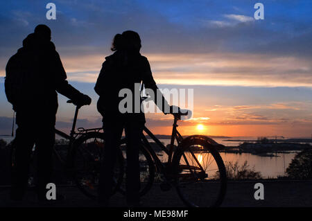 Couple with a bicycle on sunset in Kaivopuisto park, Helsinki, Finland. Stock Photo
