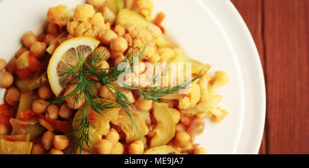 Vegetable stew with chickpeas, cauliflower and cabbages. Organic food. Vegan dish. European cuisine. Vegetarian lunch. Toned photo. Close up. Top view Stock Photo