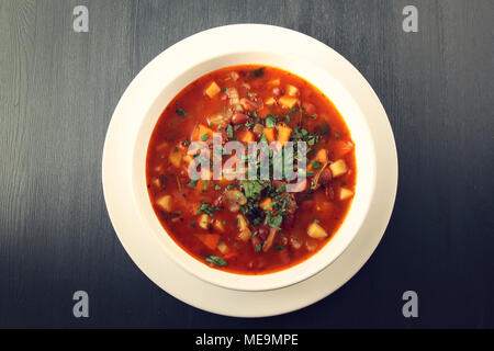 Tomato soup with red beans, potato and carrot. Vegan diet. European cuisine. Vegetarian dish. Main course. Organic meal. Copy space. Top view. Stock Photo