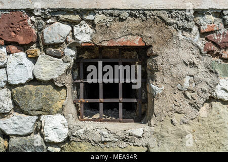 Old prison window in castle cell wall with metal bars, dark age Stock Photo