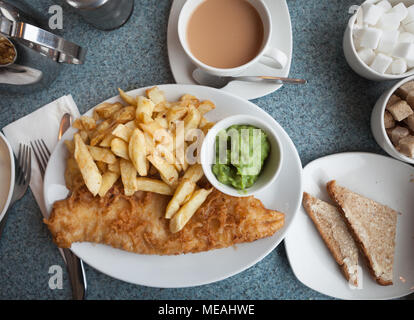 Authentic British fish and chips, with mushy peas, buttered bread and a cup of tea Stock Photo