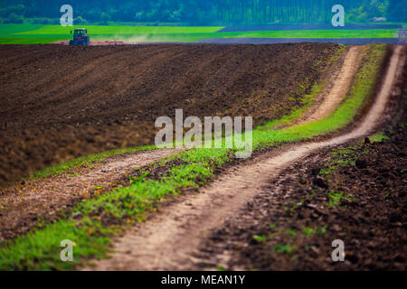 Farmer in tractor preparing farmland with seedbed for the next year Stock Photo