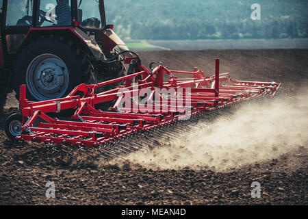 Farmer in tractor preparing farmland with seedbed for the next year Stock Photo