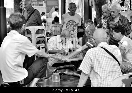 Singapore - April 13th 2018: A group of elderly Chinese men enjoying a game of traditional chess in Chinatown Stock Photo