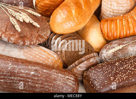 Freshly baked rye and wheat bread on the table. Whole and sliced loaves. Food concept. Selective focus Stock Photo