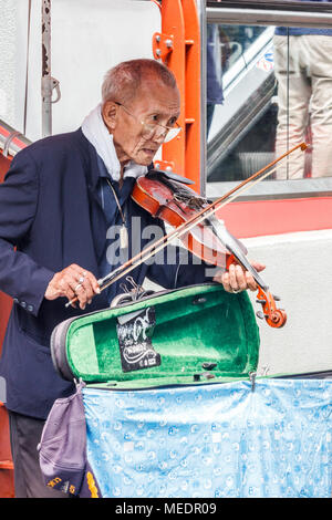 Old man with violin busking for money, Bangkok, Thailand Stock Photo